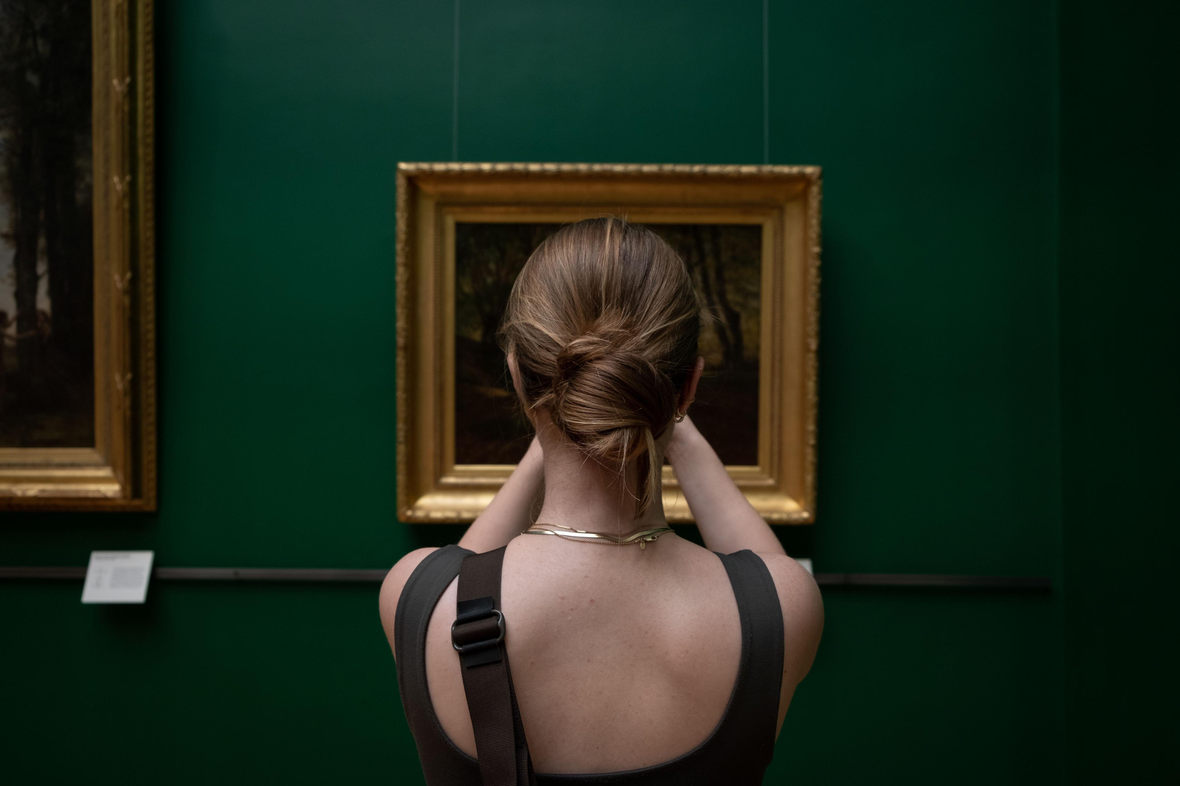 A visitor standing in front of an artwork in a museum